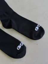 Par de medias largas negras con diseño de carita feliz y texto "BERKAMO" en blanco en la parte superior.