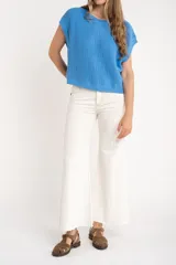 Chaleco sin mangas de tejido de punto color rosado pálido, con textura calada y acabado lurex, corte al cuerpo y cuello redondo.