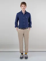 Pantalón chino de hombre color azul marino, de corte slim fit, confeccionado en gabardina de algodón, con bolsillos laterales y traseros, y cierre frontal de cremallera y botón.
