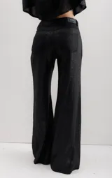 Pantalón de pierna ancha con acabado brillante, confeccionado en lino. Presenta un diseño de tiro medio con cierre de botón y cremallera, bolsillos traseros y etiqueta de marca en la cintura.