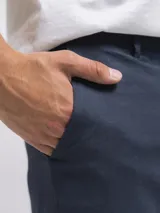 Bermuda de lino color azul marino, de corte recto y largo a la rodilla. Presenta bolsillos laterales y cierre frontal.