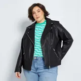 Campera negra de cuero sintético con cuello dentado, cierre cruzado con cremallera y bolsillos laterales con cremallera.