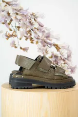 Sandalias negras de cuero con plataforma y hebillas metálicas.