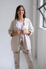 Campera tipo parka de color beige, con cierre frontal completo, capucha con cordones ajustables y mangas tres cuartos con detalle de trabilla y botón.