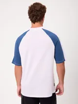 Remera holgada Rusty modelo Isel, de diseño bicolor con cuerpo azul marino y mangas ranglán blancas. Cuenta con cuello redondo ribeteado y pequeño logo bordado en el pecho.