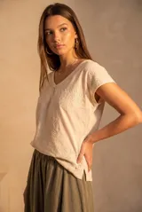 Remera de algodón flame color marfil, con escote en V, mangas cortas y delicados bordados de flores en relieve distribuidos por la prenda.