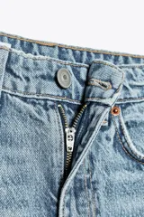 Jeans de tiro alto color negro con efecto lavado, corte mom fit, cinco bolsillos y cierre frontal con cremallera y botón metálico.