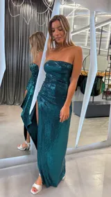 Vestido largo strapless de lentejuelas color verde esmeralda, con diseño ajustado y tajo lateral profundo.