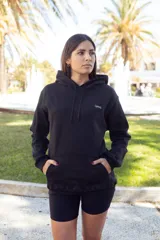 Canguro negro con capucha y cordones ajustables, bolsillo tipo canguro y logo pequeño en el pecho.