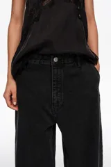 Pantalón de mezclilla negro de corte wide leg, con diseño holgado y tiro bajo.