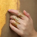 Anillo dorado con diseño espiralado y textura martillada, fabricado en acero quirúrgico con baño de oro.