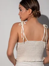 Top color crema con breteles finos para atar, frente abullonado y espalda entera en punto smock.