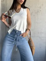 Musculosa tejida color crema con escote en V y botones laterales.