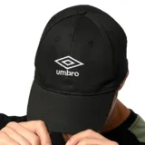 Gorra tipo cap de la marca Umbro, color negro con el logo de la marca bordado en blanco en la parte frontal.