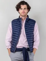 Chaleco acolchado azul marino para hombre, confeccionado en nylon reciclado repelente al agua, con diseño Slim Fit, cremallera central con detalle de bandera y bolsillos laterales.