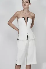 Bermuda blanca de corte amplio con detalles metálicos.