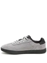 Championes Caterpillar de hombre, modelo Pause Retro T-Toe, de color gris. Confeccionados en gamuza con suela de goma negra y detalles en dorado con el nombre de la marca en el lateral.