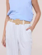 Pantalón wide leg blanco con finas rayas verticales oscuras, tiro alto, bolsillos laterales y pinzas frontales. Incluye un cinturón trenzado de rafia con hebilla rectangular.