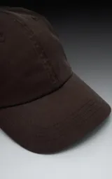 Gorra de béisbol color marrón oscuro (chocolate), de estilo clásico con visera curva y seis paneles.