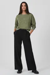 Buzo de algodón color verde oliva con cuello redondo y diseño de estrella bordada en el frente. Presenta un acabado desgastado y corte holgado.