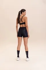 Top deportivo de compresión media con diseño de espalda cruzada y breteles finos. Confeccionado en tejido acanalado con un acabado de brillo sutil, cuenta con copas removibles y tecnología de ajuste adaptable.