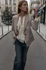 Blazer de corte sastrero confeccionado en tejido de lana con diseño de espiga. Presenta cuello con solapas, hombreras, cierre frontal con un botón y bolsillos delanteros con solapa.