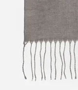Bufanda de punto doble faz en color gris, con diseño liso y terminación de flecos en los extremos.