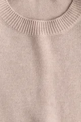 Buzo en punto fino suave de color beige con hombreras y ribete acanalado en cuello redondo, puños y bajo.