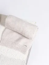 Set de accesorios de invierno en color beige melange, compuesto por un gorro tipo beanie de punto acanalado, un par de guantes de punto y una bufanda de punto con terminación acanalada.