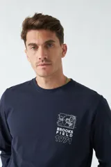 Remera de manga larga azul marino con estampado en la espalda de un tocadiscos y otros diagramas técnicos en color blanco.