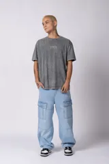 Remera gris de corte oversize con efecto acid wash y estampa pequeña en el pecho.