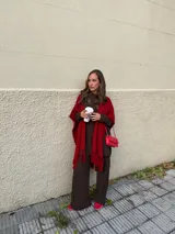 Ruana negra de tejido liviano con terminación de flecos en el ruedo y mangas amplias.