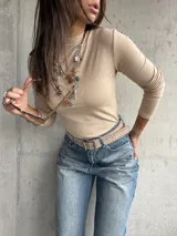 Polera de cuello alto y manga larga, confeccionada en tejido de algodón con textura acanalada y ajuste al cuerpo.