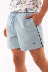 Short de baño azul con cintura elástica y cordón ajustable. Tiene dos bolsillos laterales y un bolsillo trasero.