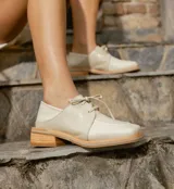 Zapato acordonado de cuero vacuno con acabado desgastado, de horma cuadrada y suela de goma con pequeño taco.