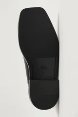 Botas Chelsea de cuero negro con paneles elásticos laterales, suela gruesa y puntera redonda reforzada con una pieza metálica plateada.