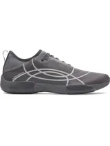 Championes de entrenamiento Under Armour modelo UA W Sculpt TR, color gris oscuro con diseño de líneas abstractas en tono más claro. Presentan una estructura de micromalla transpirable, lengüeta de una sola pieza y entresuela de amortiguación EVA.