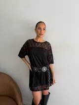 Remerón de encaje negro con mangas cortas y cuello redondo, acompañado de un vestido strapless interior corto en el mismo tono.