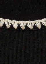 Camiseta negra de algodón con cuello redondo y mangas cortas con ribetes blancos en contraste.