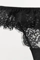 Tanga de encaje negro con tiro medio y cintura elástica con volante a tono.