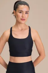 Top deportivo de compresión media con diseño de espalda cruzada y breteles finos. Confeccionado en tejido acanalado con un acabado de brillo sutil, cuenta con copas removibles y tecnología de ajuste adaptable.