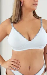 Soutien triángulo básico negro sin aro, confeccionado en algodón elastizado con breteles finos y contorno inferior con estampado floral.