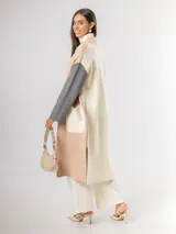 Sacón tipo tapado de corte largo, confeccionado en tejido de punto con diseño color block en tonos gris, negro y blanco. Presenta cierre frontal con botones, bolsillos laterales de parche y aberturas en los costados.