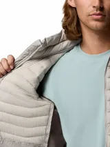 Campera híbrida Columbia con aislamiento térmico, diseño acolchado y paneles laterales elásticos. Cuenta con cierre frontal completo, cuello alto con protector de mentón y bolsillos laterales con cierre.