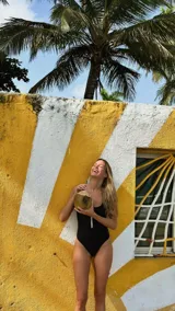 Traje de baño enterizo negro de lycra, corte vedetina y cierre frontal con cremallera blanca.