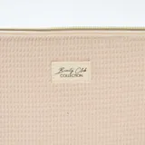 Neceser de diseño acolchado con textura tipo waffle en color beige. Presenta bordes con terminación festoneada, cierre superior metálico y etiqueta frontal con la inscripción Beauty Club Collection.