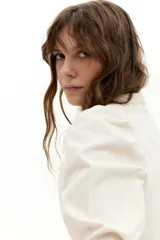 Camisa de corduroy color crudo, con cuello mao, cierre frontal con botones de nácar, mangas largas y detalle de tablas en los hombros que aportan volumen.