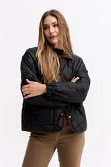 Campera matelaseada de diseño en rombos color verde oliva, con cuello y bordes en contraste color marrón. Presenta cierre frontal con botones a presión, mangas largas con puños elásticos y corte holgado.