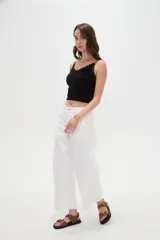 Pantalón de jean blanco de tiro medio, con diseño de silueta barrel, bolsillos clásicos y costuras con pinzas decorativas en la zona de las rodillas.
