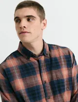 Camisa de franela de manga larga con estampado de cuadros escoceses, cuello button-down y cierre frontal con botones.